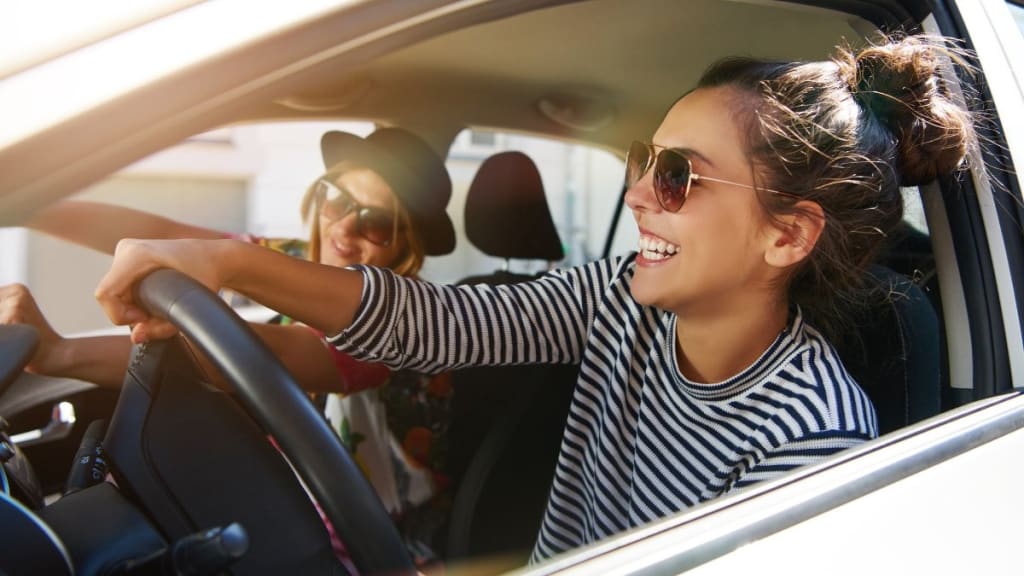 Two young women driving a car.